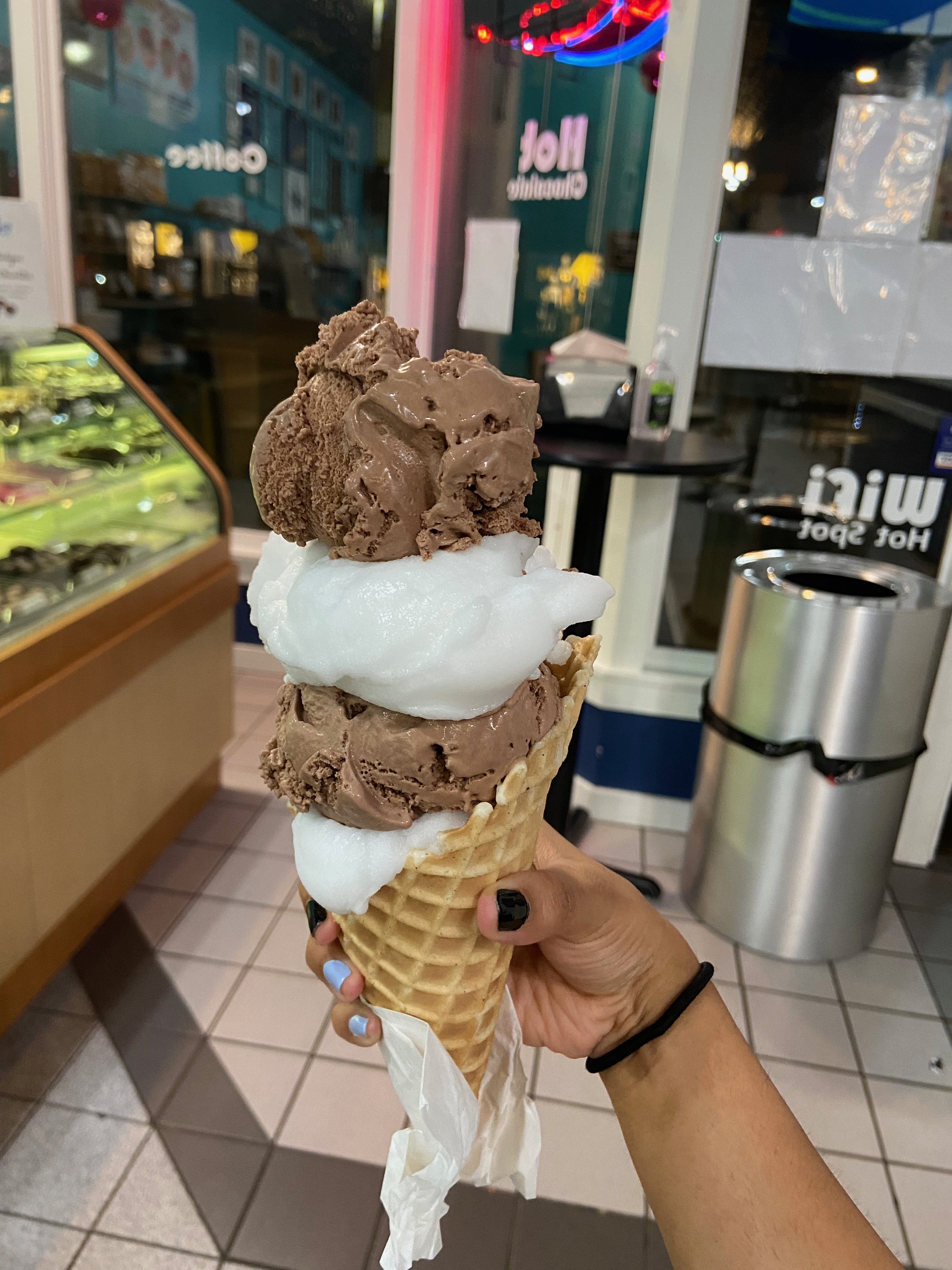 A four-scoop ice cream cone, alternating scoops of lemon sorbet and non-dairy chocolate ice cream.