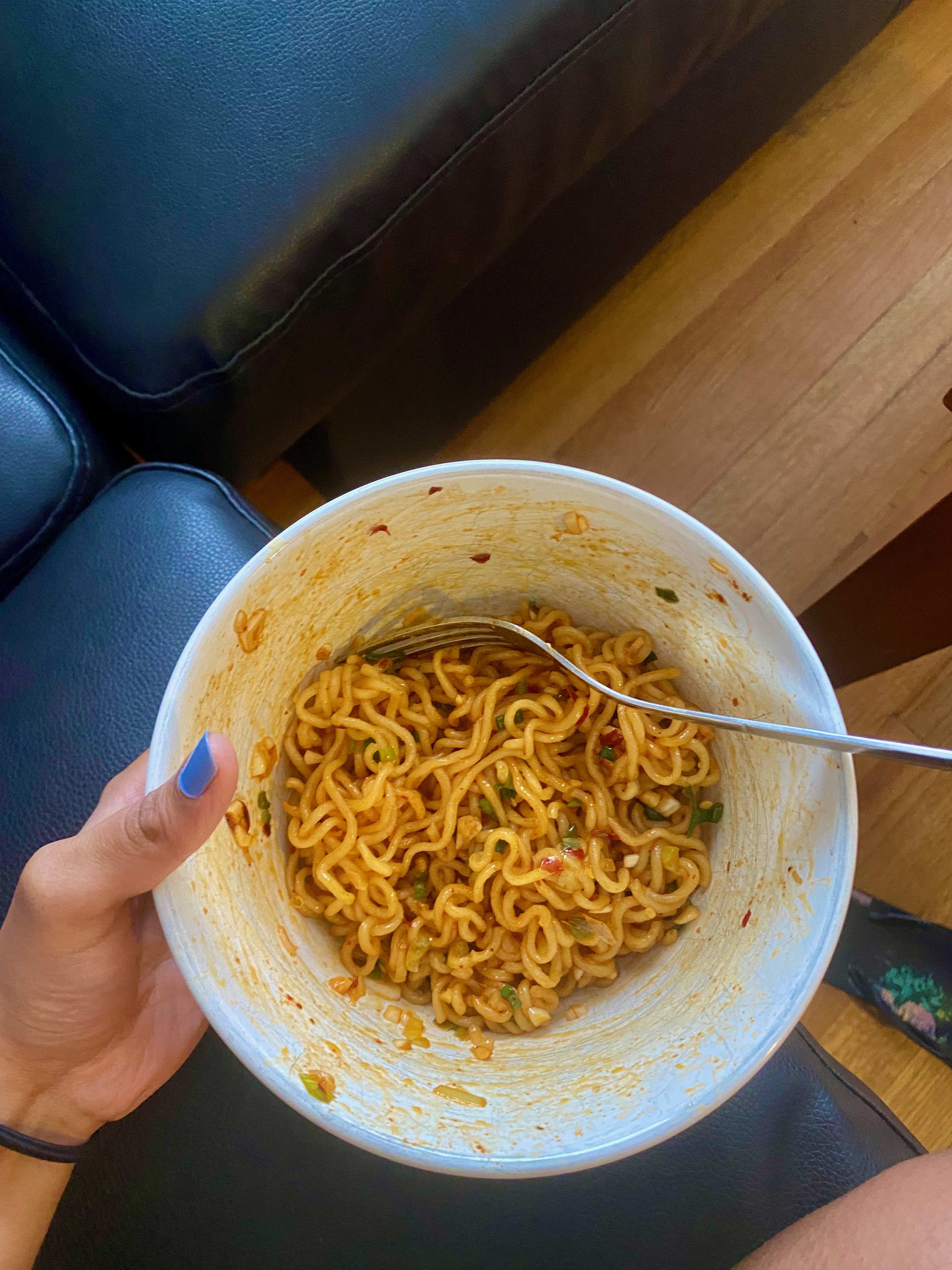 A bowl of ramen spruced up with spring onions, minced garlic, and red pepper flakes.