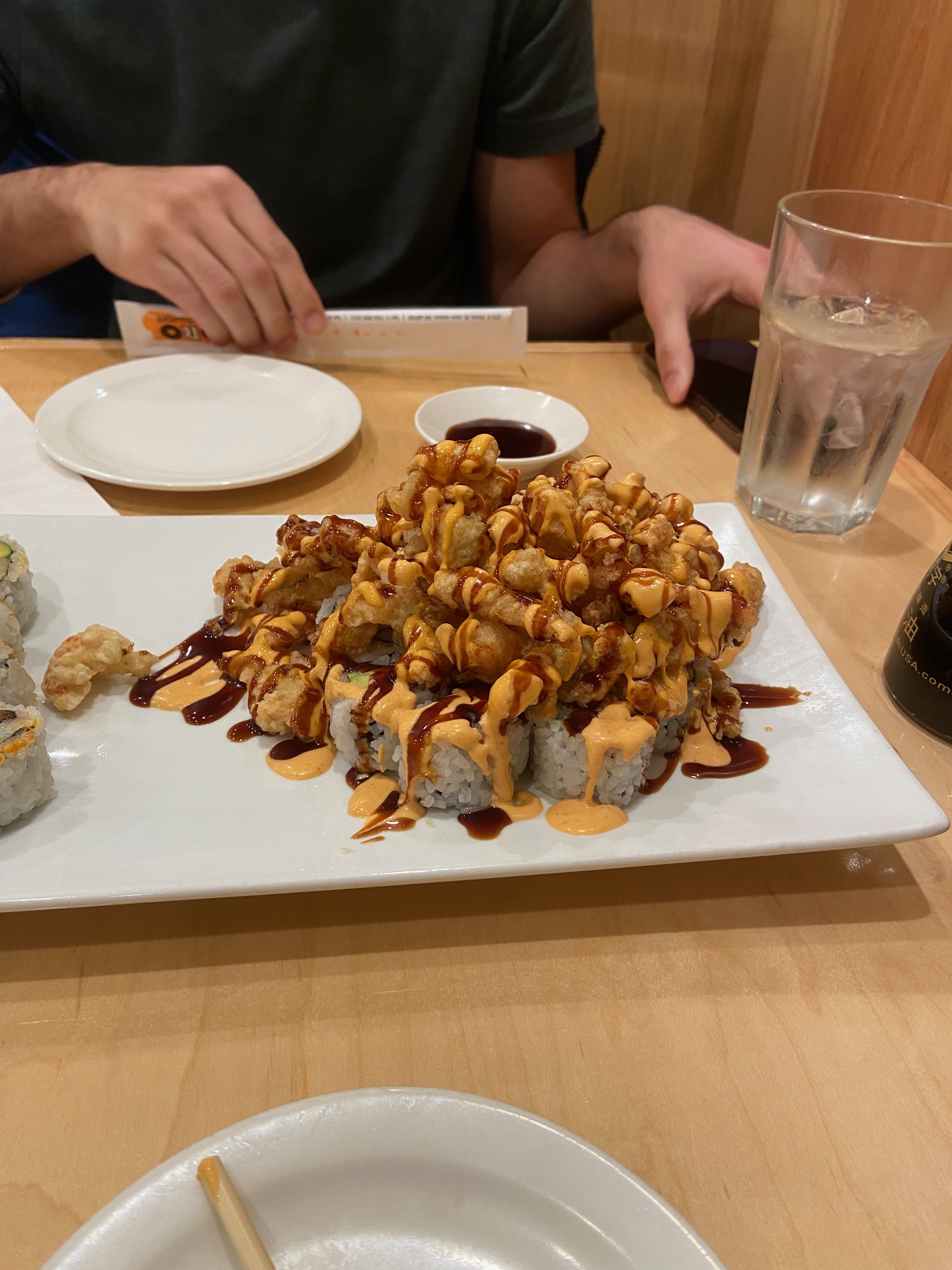 Sushi: a special California roll topped with deep-fried lobster and drizzled with eel sauce and spicy mayo